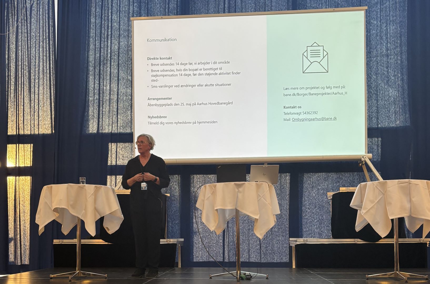 Projektchef Helle Thambo præsenterer første del af Aarhus H-projektet 2025 Projektchefen for første del af Aarhus H-projektet står på en scene og forklarer til borgerne, hvad de skal forvente af projektet